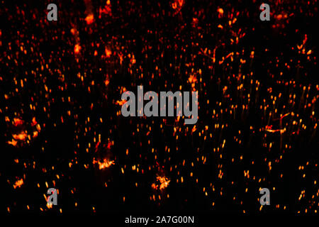 Sfocato sfondo scuro - arancione scintille nelle tenebre Foto Stock