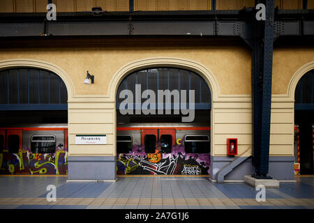 Il porto del Pireo Grecia città metropolitana capolinea della metropolitana di Atene linea 1 un graffiti copre treno parte sotto egli stazione ornati shed Foto Stock