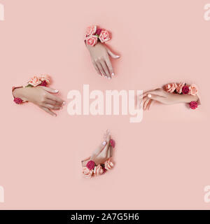 Impostare le mani con fiori artificiali fuori del foro rosa lo sfondo della carta. Mano in pose diverse, il modello layout per il collage. Cosmetici ha Foto Stock