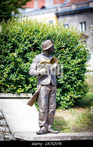 TALLINN, Estonia - Luglio 05, 2019: color bronzo statua vivente con una spazzola e strumento musicale stand su una parete a Tallinn in Estonia nel luglio 2019 Foto Stock