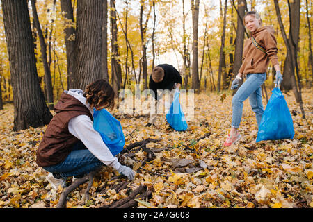 Un gruppo di volontari nel cestino di raccolta in una foresta stagionale in autunno Foto Stock