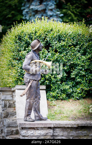 TALLINN, Estonia - Luglio 05, 2019: color bronzo statua vivente con una spazzola e strumento musicale stand su una parete a Tallinn in Estonia nel luglio 2019 Foto Stock