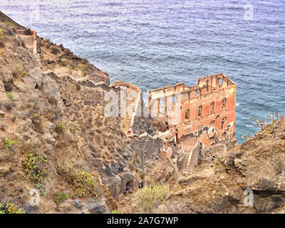 Un vecchio rudere sul pendio ripido della costa a nord delle isole Canarie di Tenerife. Una ripida scalinata fatiscente conduce in basso verso la rovina. B Foto Stock