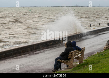 Southend on Sea, Essex, Regno Unito nell'estuario del Tamigi era ancorato con il vento e la pioggia dalla tempesta davanti che attraversano il paese. La gente è piaciuto camminare lungo il lungomare tuttavia come le onde che si è schiantato sul mare parete. Conseguenze dell'Uragano Pablo Foto Stock