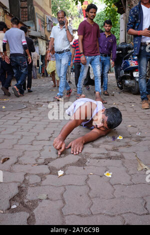 Un uomo indù striscia sul ventre per eseguire Dandwat Pranaam durante la celebrazione di Chhath Puja a Banganga Tank, Walkeshwar, Mumbai, India Foto Stock