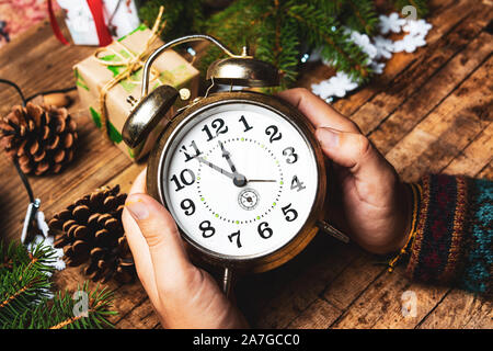Persona in possesso di un orologio vintage in ambiente festoso pov Foto Stock