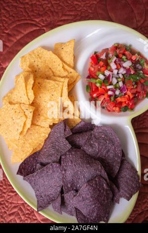 Organici di blu e giallo Tortilla hips con una gustosa salsa organico Foto Stock