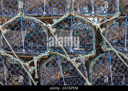 Aragosta e granchio pentole impilati pronti per l'uso da pescatori sul lato del quayside a ben accanto al mare sulla costa nord norfolk, Anglia est, regno unito. Foto Stock