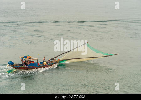 Da Nang, Vietnam - Marzo 10, 2019: Tien Sa Porto di Da Nang Bay. Piccola barca da pesca con verde anteriore caricato in movimento netto sul mare di colore verdastro acqua mentre due Foto Stock