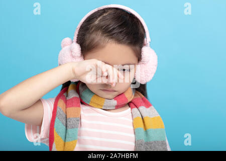 Triste e stanco bambina abiti invernali, guardando verso il basso Foto Stock