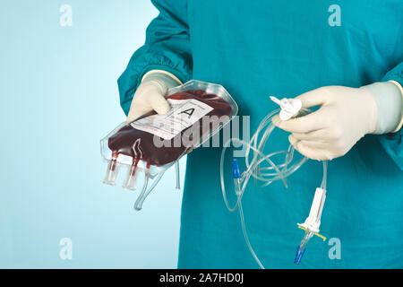 Tecnico chirurgico prepara unità di tipo un donatore di sangue che deve essere trasferita durante la chirurgia. Foto Stock