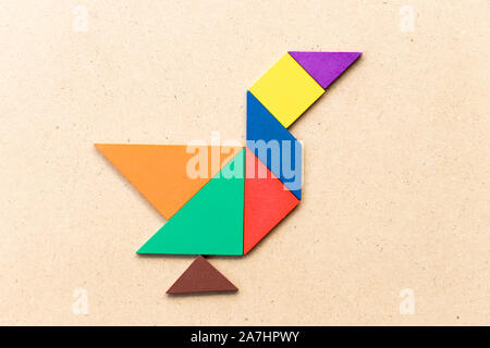 Colore tangram puzzle in anatra, swan o forma d'oca su uno sfondo di legno Foto Stock