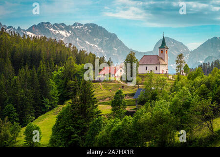 Sloveno paesaggio di montagna con la Chiesa. San Spirito ( Sveti duh) chiesa sul crinale del monte e Kamnik-Savinja Alpi in background, Slovenia, Europa Foto Stock