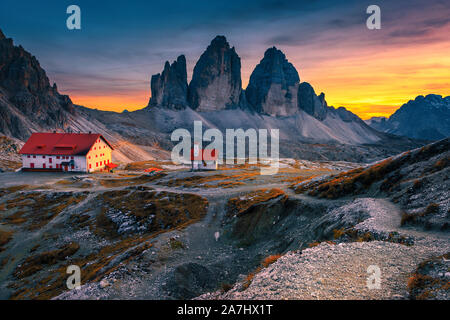 Il pittoresco Tre Cime di Lavaredo (Drei Zinnen) montagne con il famoso Rifugio Locatelli rifugio alpino e la piccola cappella al tramonto colorato, Dolomiti, Ita Foto Stock