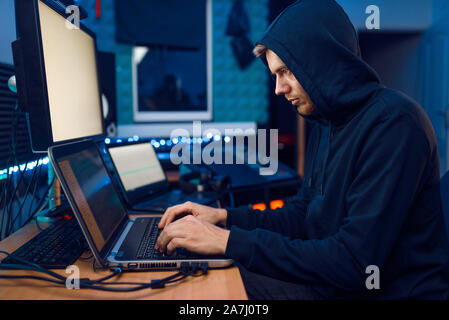 Hacker seduti al computer portatile, informazioni hacking Foto Stock