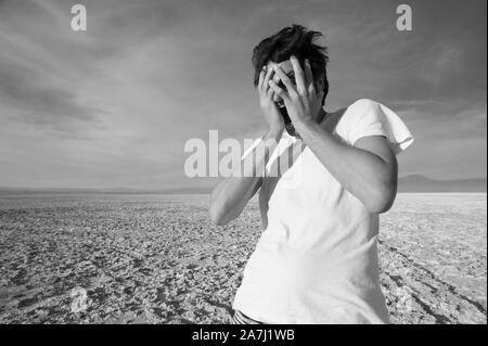 San Pedro de Atacama, Antofagasta, Cile - 01 Novembre 2012: urla giovane protegge il suo volto dal forte vento del deserto di Atacama Foto Stock