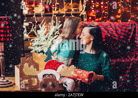Bella madre con figlia festeggia il Natale a casa. Foto Stock