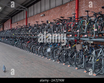 Fila di biciclette saldamente bloccata, un intero ciclo di rack su una piattaforma del treno Foto Stock