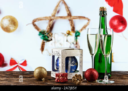 Champagne in bicchieri e in una bottiglia. Natale romantico sfondo. Nelle vicinanze si trova un giocattolo di Natale. luogo per il testo Foto Stock