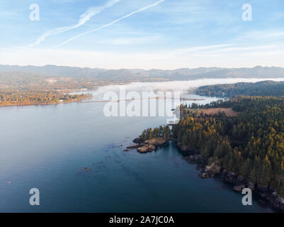 Vista aerea di un banco di nebbia di mare nello spostamento verso il basso di una baia su un robusto Vancouver Island costa. Foto Stock