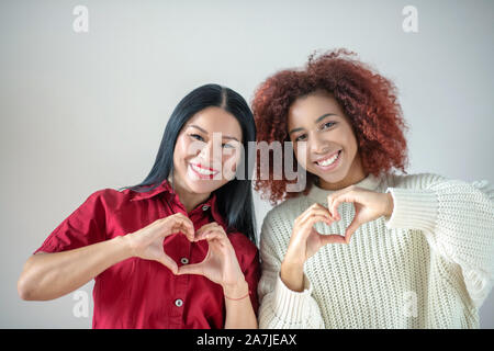 Amici internazionali ampiamente sorridente che mostrano il loro amore Foto Stock