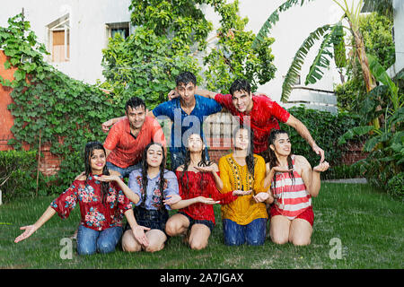 Group-Of happy amici adulti uomini e donne nel giardino di casa e divertirsi godere The-Rain Foto Stock