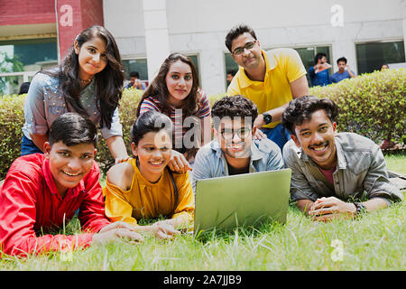 Gruppo studenti del college amici nel campus di terra e lo studio con il computer portatile Foto Stock