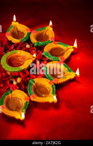 Close-up Diyas masterizzazione olio-lampada con illuminazione Flowers-Petals On-Diwali celebrazione del Festival in India Foto Stock