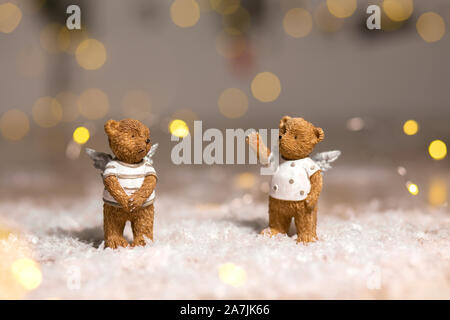 Figurine decorative di un tema natalizio. Figurine di orsi con ali d'angelo. Decorazioni festive, caldo bokeh luci. Foto Stock