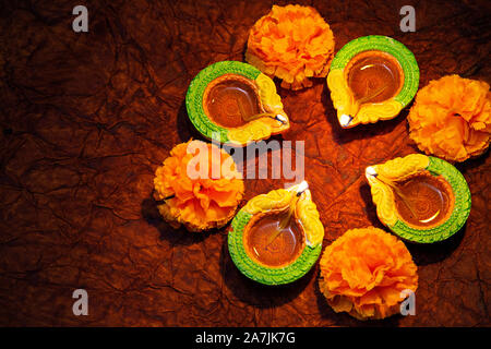 La masterizzazione Diyas olio lampade di illuminazione con fiori su Diwali Festival celebrazione Foto Stock