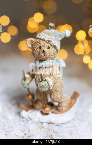 Decorazione di Natale figurine a tema. Statuetta di un orso di peluche di sci. Decorazione per albero di Natale. Decorazioni festive, calde luci bokeh di fondo Foto Stock