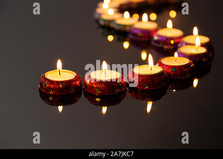 Candele accese di illuminazione in una linea curva il Diwali Festival celebrazione Foto Stock