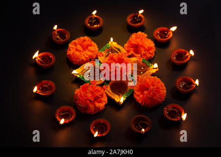 Nessuno Shot Burning Diya Oil-Lamp con fiori illuminato di luce Diwali Festival celebrazione Foto Stock