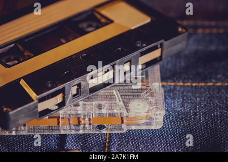 Riproduttore di cassette audio su jeans tessuto nelle tenebre. Concetto di vintage 90s music player. Foto Stock