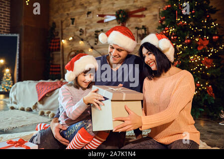 Famiglia dà un regalo in camera per Natale Foto Stock