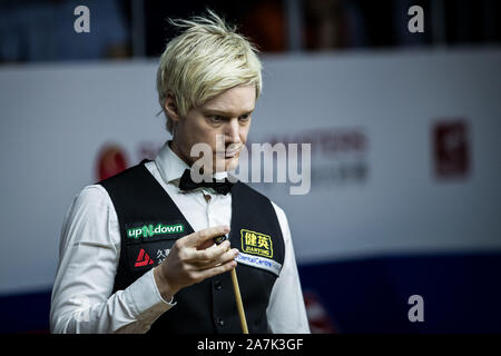 Neil Robertson di Australia chalks spunto durante il match contro Ding Junhui della Cina in occasione del secondo round del 2019 Snooker Masters di Shanghai in Shang Foto Stock