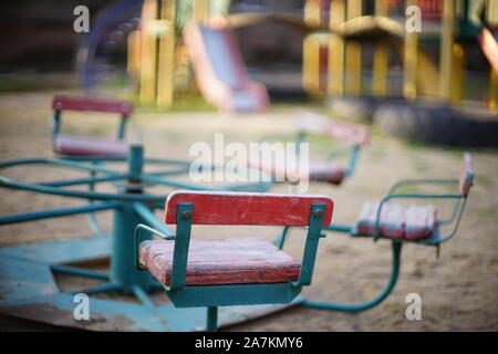 Parco giochi per bambini con una vecchia giostra nella sabbia closeup. Foto Stock