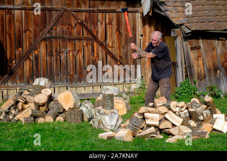 Uomo che utilizza un frazionamento maul in giardino per dividere i registri per il carburante in preparazione per la prossima stagione invernale Zala county Ungheria Foto Stock