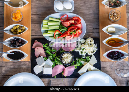 Preparazione di una ricca colazione mediterranea per un gruppo. Foto Stock