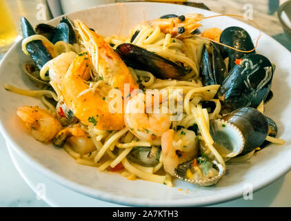 Seafood Linguini pasta con cozze crevettes cardidi re boreale con peperoncino e aglio pane è servita in un ristorante specializzato Foto Stock