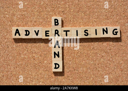 Marchio, pubblicità e parole in 3d alfabeto in legno lettere in forma cruciverba su una bacheca di sughero sfondo Foto Stock