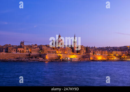 Fortificata città vecchia di La Valletta in serata in Malta, skyline dal mare. Foto Stock