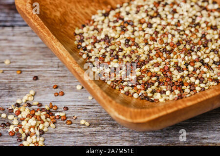 Materie di quinoa calli in una ciotola di legno su una superficie di legno Foto Stock