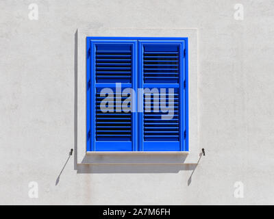 Chiuso persiane in legno di colore blu sul muro bianco della tipica del Mare Mediterraneo vintage house Foto Stock