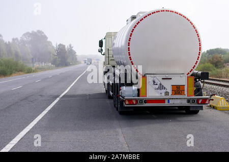 Autobotte di merci pericolose su strada un nebbioso giorno Foto Stock