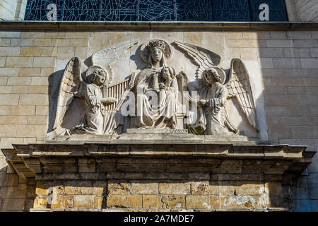 Angelic scolpita in pietra sopra il fregio del portale di la chiesa di San Nicola, Bruxelles, Belgio. Foto Stock