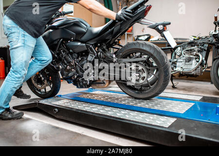 Lavoratore di mettere in moto un ascensore, la preparazione per la riparazione in officina Foto Stock