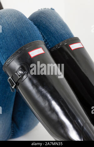 Donna nera Stivali in gomma con jeans blu Foto Stock