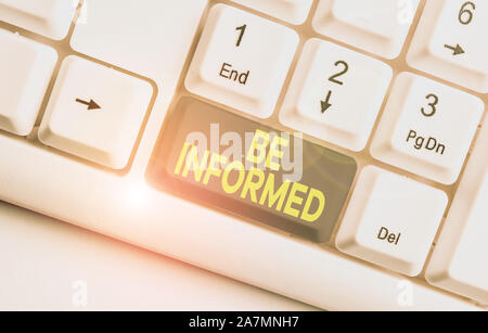 La scrittura della nota mostra essere informati. Il concetto di business per aver o mostrando una conoscenza di soggetti o situazioni White tastiera PC con nota sopra carta Foto Stock