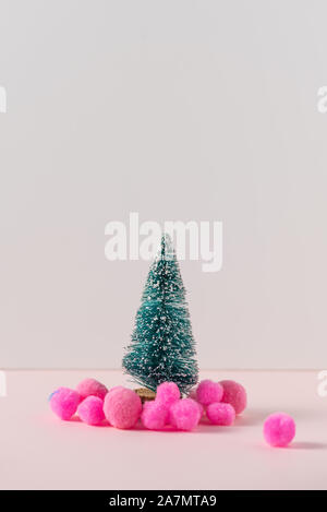 Modello in miniatura inverno pino con neve sfere rosa decorazione, con atmosfera festa di Natale. Piccolo giocattolo nevoso albero di Natale Concetto di nuovo Y Foto Stock